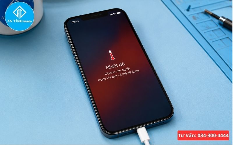 Hình ảnh thực tế một chiếc iPhone đang cắm dây sạc, màn hình hiển thị thông báo nhiệt độ quá cao, bên cạnh là nhiệt kế hồng ngoại đo nhiệt độ mặt lưng máy.